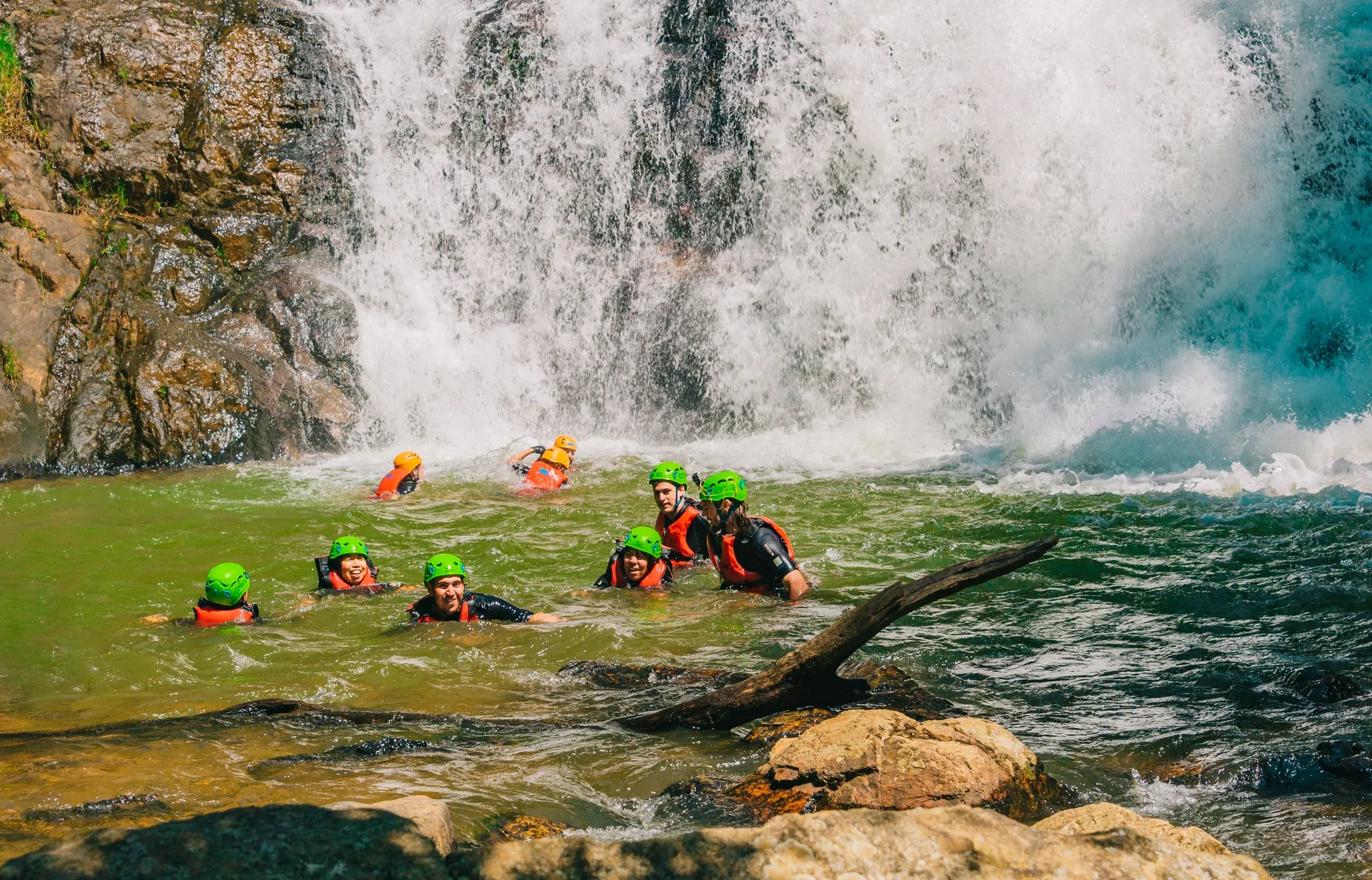 Groupe équipé pour une activité de canyoning au pied d’une cascade