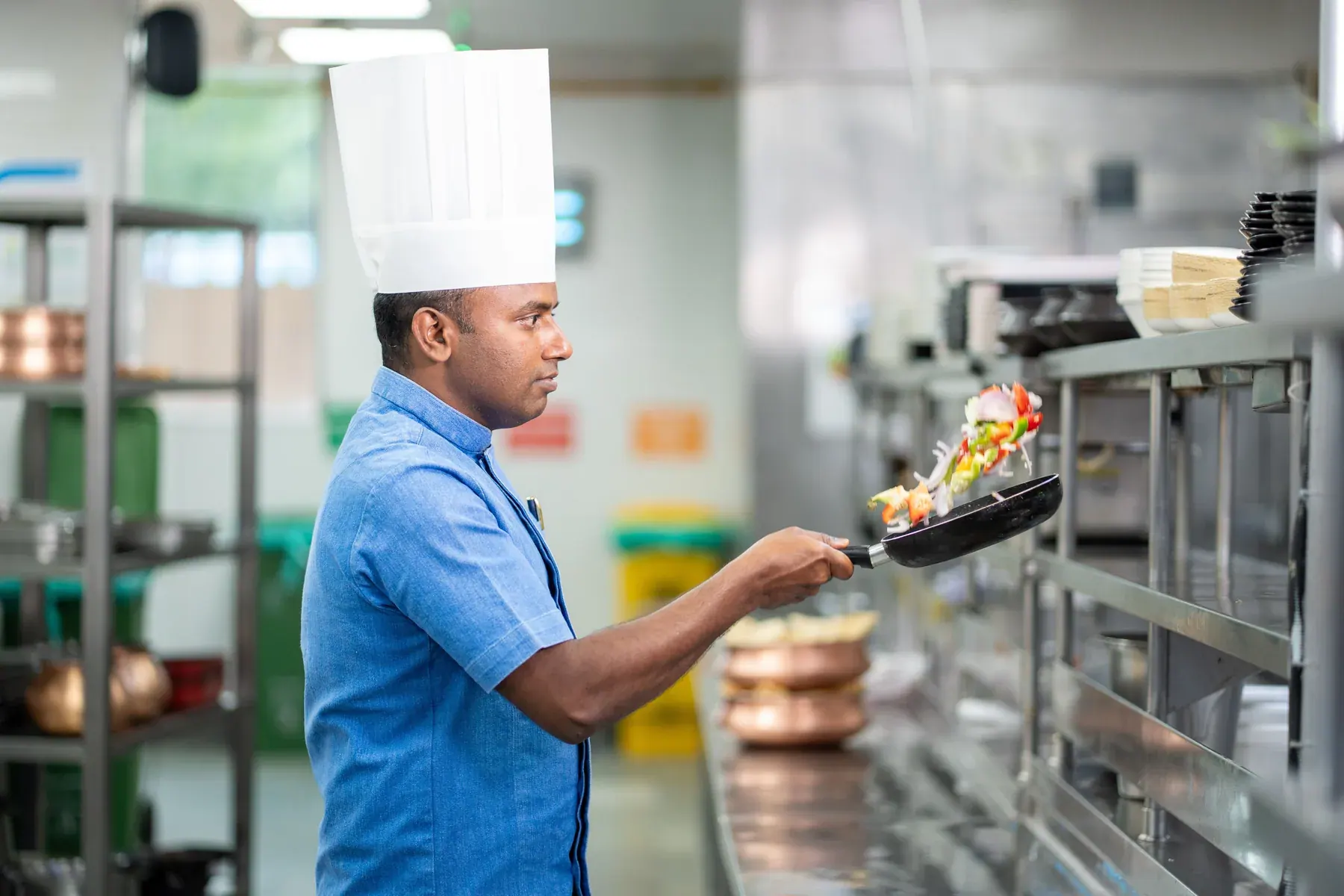 Professionnel de cuisine réalisant un geste technique pendant le service