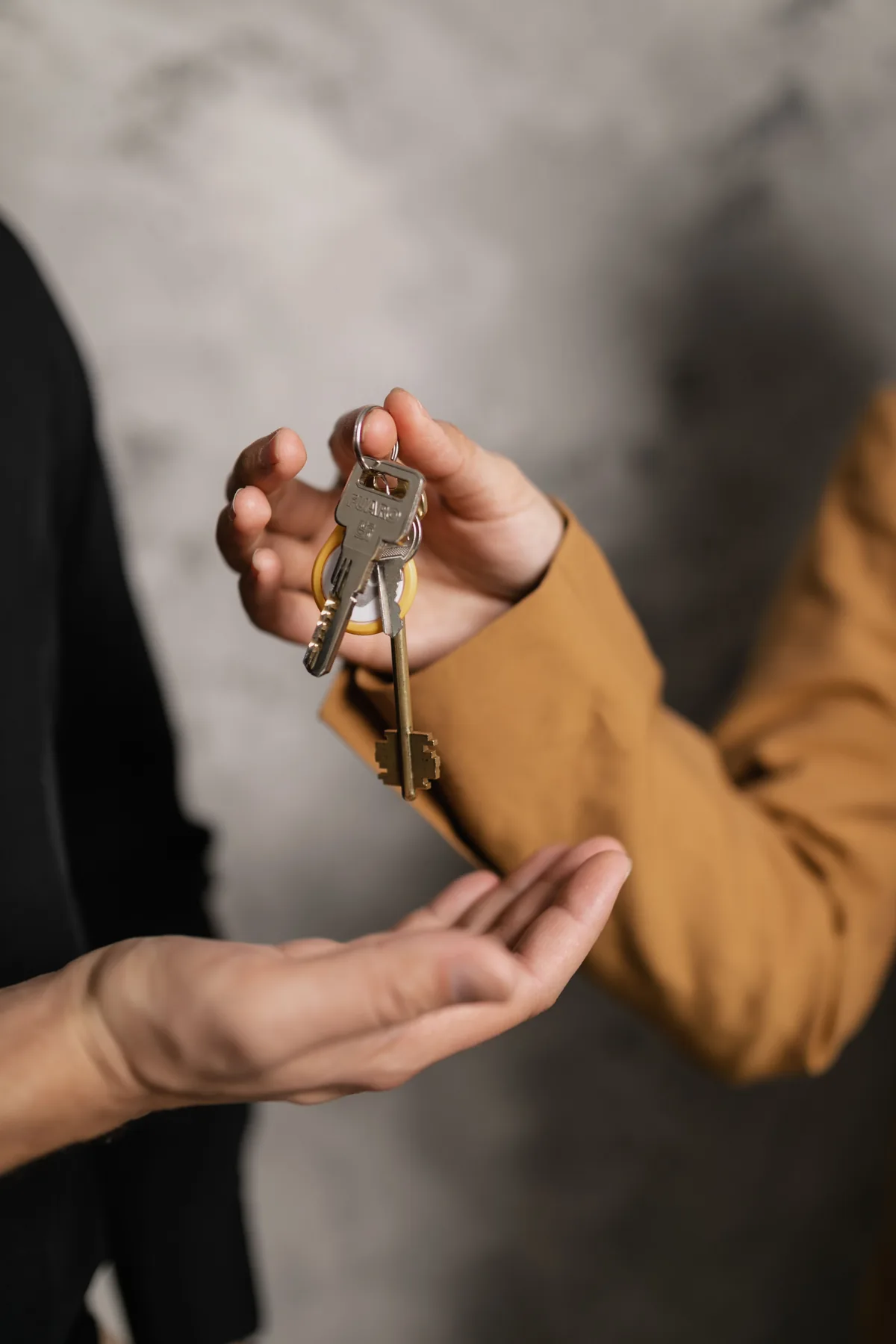 Remise des clés d’un hébergement entre une conciergerie et un voyageur